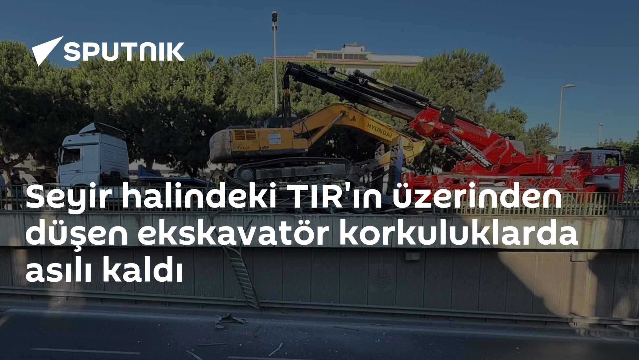 Seyir halindeki TIR'ın üzerinden düşen ekskavatör korkuluklarda asılı kaldı
