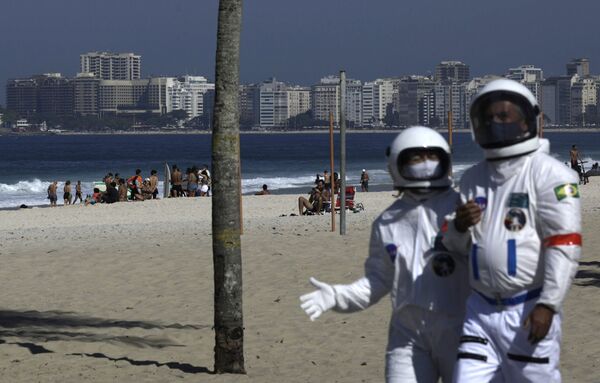 Kovid-19’dan korunmak için astronot kıyafeti giyen yaşlı çift, sahilde dolaştı - Sputnik Türkiye