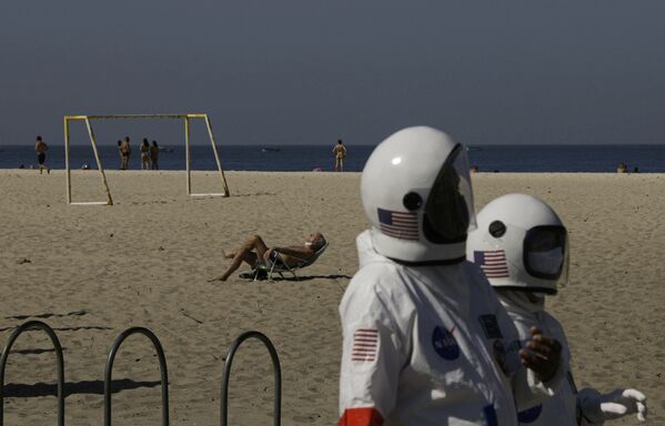 Kovid-19’dan korunmak için astronot kıyafeti giyen yaşlı çift, sahilde dolaştı - Sputnik Türkiye