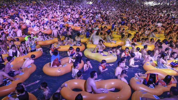 Koronavirüsün çıktığı kent olarak anılan Vuhan'da binlerce kişi, hafta sonu hiçbir önlem almadan su parkındaki partiye katıldı. - Sputnik Türkiye