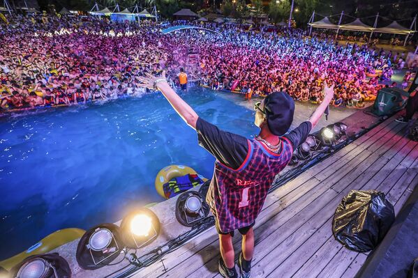 Vuhan Maya Plaj Suyu Parkı'nda düzenlenen elektronik müzik festivaline katılan kalabalık, balık istifi şekilde maske ve hiçbir güvenlik tedbiri olmadan havuzlara doluştu. - Sputnik Türkiye