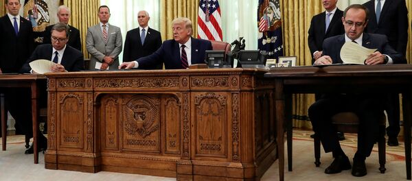 Sırbistan Cumhurbaşkanı Aleksandar Vucic (solda) ile Kosova Başbakanı Avdullah Hoti (sağda), ABD Başkanı Donald Trump'ın katıldığı törende 'ekonomik normalleşme' anlaşması imzalarken - Sputnik Türkiye