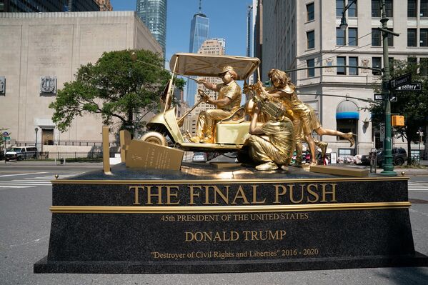 Trump’ı canlandıran sanatçı ise altın rengine boyanmış golf sopasını bir kılıç çekmişçesine önüne işaret ediyor. - Sputnik Türkiye