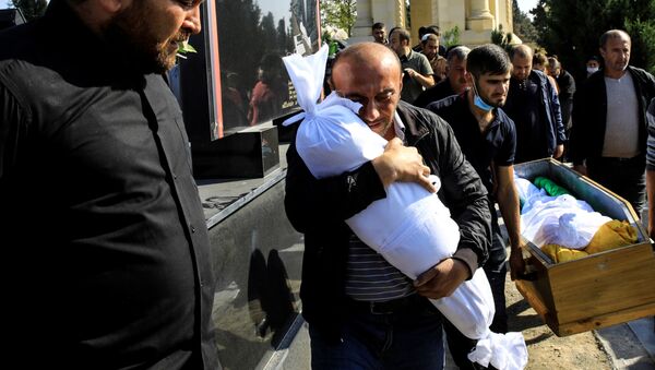 Dağlık Karabağ çatışmalarında vurulan Azerbaycan'ın Gence kentinde annesi dahil beş akrabasının yanısıra ölen 10 aylık bebek Narin'le vedalaşan babası - Sputnik Türkiye