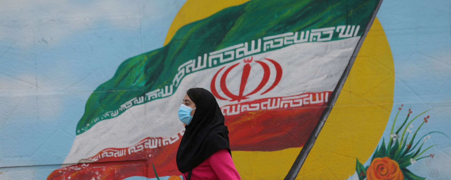 Tahran'da İran bayraklı duvar resminin önünden geçen maskeli kadın - Sputnik Türkiye, 1920, 01.01.2023