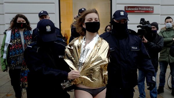 Polonya'da Anayasa Mahkemesi'nin kürtaj yasağı kararını Cumhurbaşkanlığı Sarayı önünde soyunarak protesto eden biri erkek iki sanatçıdan Ania Bielawska, polis tarafından götürülürken - Sputnik Türkiye