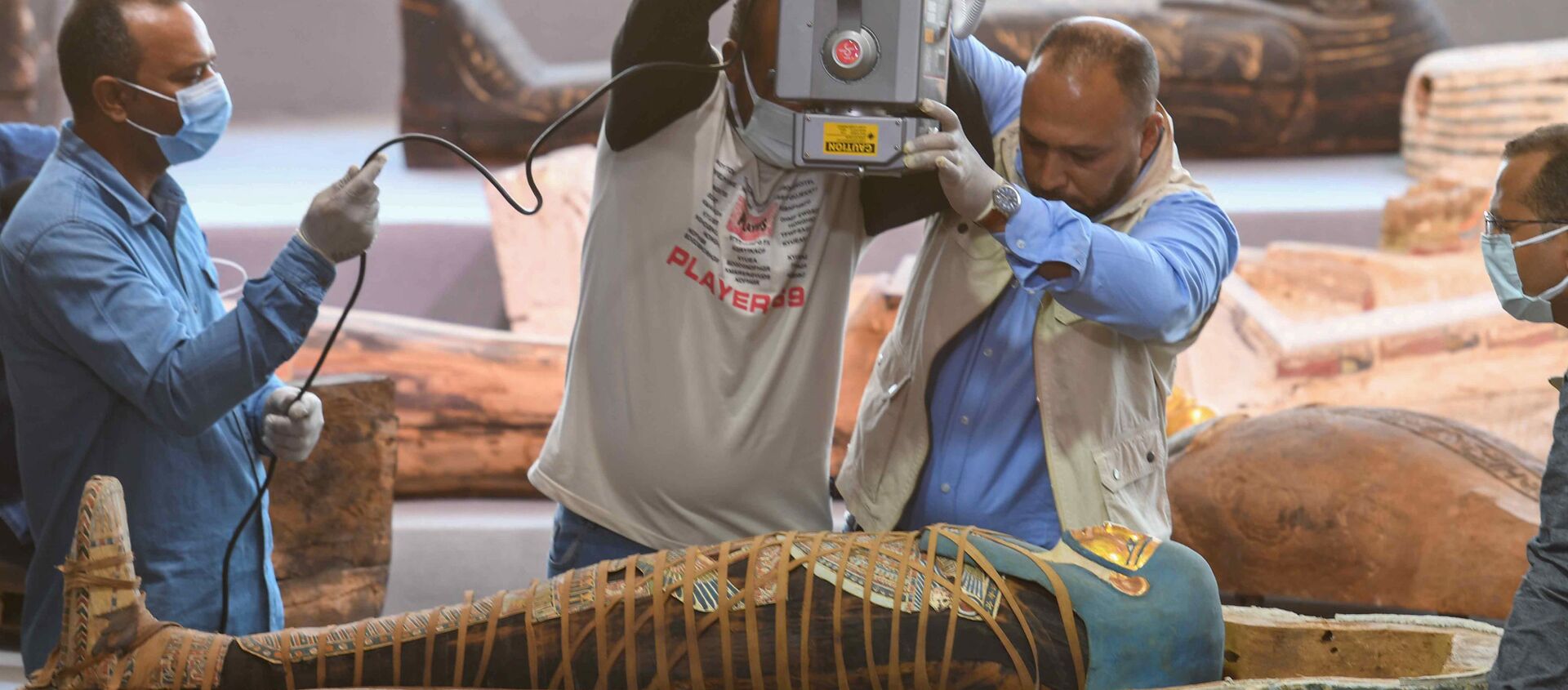 Mısır'ın  en eski antik başkenti Memphis'in Sakkara nekropolünde bulunan 2500 yıldan daha eski 100'den fazla lahitten çıkan mumyayı röntgen cihazıyla inceleyen arkeologlar - Sputnik Türkiye, 1920, 15.11.2020