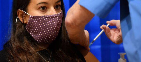 Kovid-19 pandemisi nedeniyle Britanya'nın en büyük aşı programı hayata geçti: İlk günde Galler bölgesinin Cardiff kentinde BioNTech-Pfizer aşısı yapılan bir kadın - Sputnik Türkiye