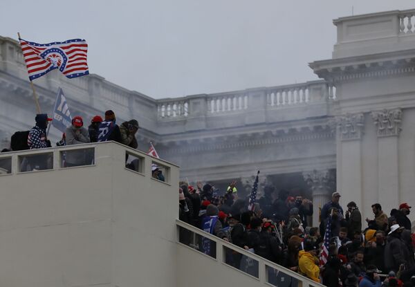 Binayı çevreleyen Trump destekçileri tırmanarak balkon üzerinden ana girişe ulaştı. - Sputnik Türkiye