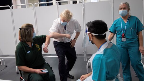 Bristol'de bir stadyumdan dönüştürülen toplu aşılama merkezini ziyaret eden Başbakan Boris Johnson, sağlık çalışanlarına dirsek selamı verirken - Sputnik Türkiye
