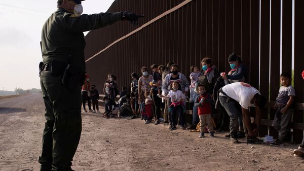 Meksika'dan tekneyle Rio Grande nehrini geçerek ABD sınırına varan göçmenleri duvar önünde sıraya dizen ABD'li federal sınır koruma ajanları (Penitas, Teksas) - Sputnik Türkiye