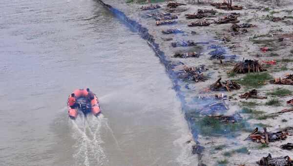 Hindistan’da şiddetli yağışın ardından Ganj Nehri yükseldi. Nehrin geri çekilmesinin ardından sahile gömülen koronavirüs kurbanlarının cesetleri yüzeye çıktı. - Sputnik Türkiye