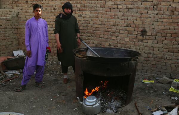 Taliban'dan kaçan  ve Kabil'deki mülteci kampına sığınan Afganlılar, yemek pişirirken - Sputnik Türkiye