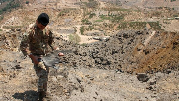 Lübnan'ın İsrail sınırındaki bölgeye düzenlenen İsrail hava saldırılarından arta kalan mühimmatı inceleyen Lübnan askeri - Sputnik Türkiye