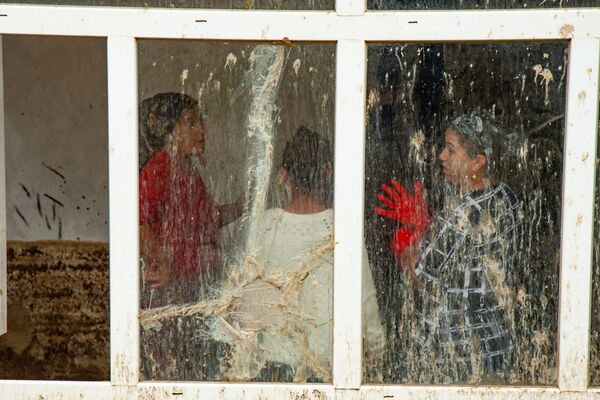 Selin getirdiği çamurla dolan evlerini temizlemeye çalışan kadınlar.
 - Sputnik Türkiye