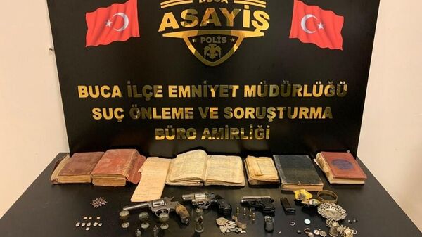 İzmir’in Buca ilçesinde durdurulan bir taksideki şüphelinin çantasında 3 tabanca, 1 Kore madalyası ve tarihi eser niteliği taşıdığı değerlendirilen 95 obje ele geçirildi. - Sputnik Türkiye