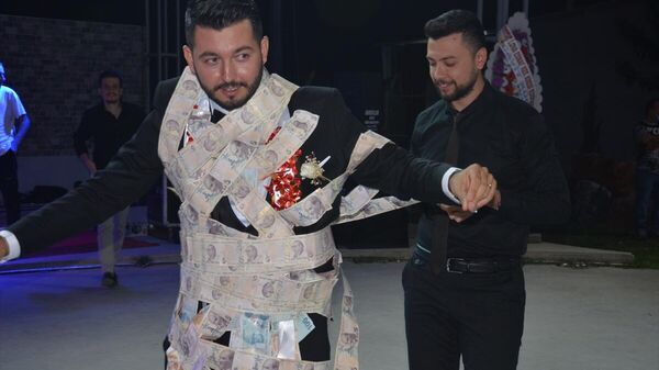 Aydın'ın İncirliova ilçesinde, iki arkadaş, düğünde damada 60 metre uzunluğunda 5 liralık banknotlar taktı. - Sputnik Türkiye