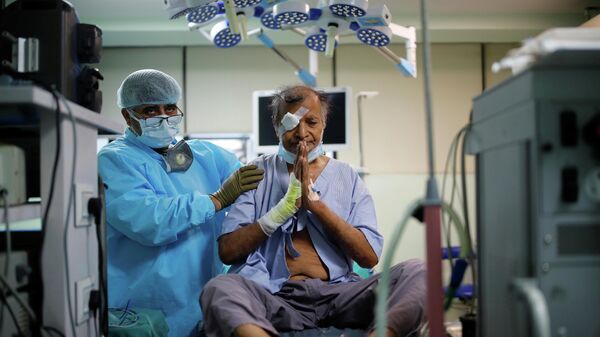 Kovid sonrası mukormikoz (kara mantar) enfeksiyonuna yakalanan Mata Ambar Tripati (65) hastanede gözünün alınmasının ardından muayene edilirken (Hindistan, Yeni Delhi, Gaziabad, Haziran 2021) - Sputnik Türkiye