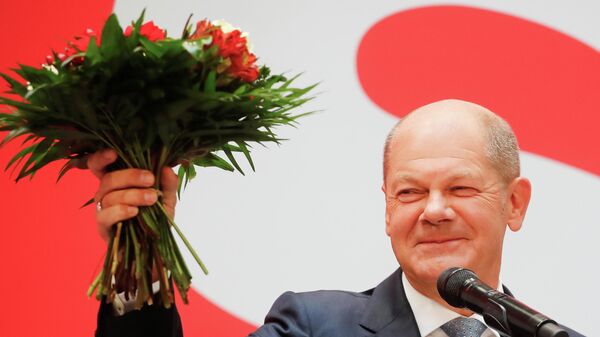 Almanya'da genel seçim ertesi Sosyal Demokrat Parti (SPD) merkezinde düzenlenen kutlamada başbakan adayı Olaf Scholz elinde çiçek buketiyle - Sputnik Türkiye