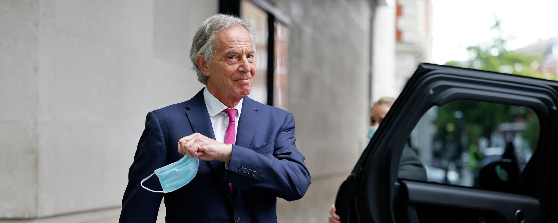 Eski Britanya Başbakanı  Tony Blair, Haziran 2021'de Andrew Marr Show'a katılmasının ardından BBC binasından ayrılırken maskesini çıkarıyor. - Sputnik Türkiye, 1920, 05.01.2022
