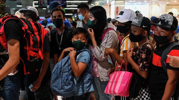 Kovid vakalarında patlamayla boğuşan Filipinler'in Metro Manila bölgesinde yılbaşı döneminde bölgelere seyahat için otobüs terminallerinde izdiham yaşandı.  - Sputnik Türkiye