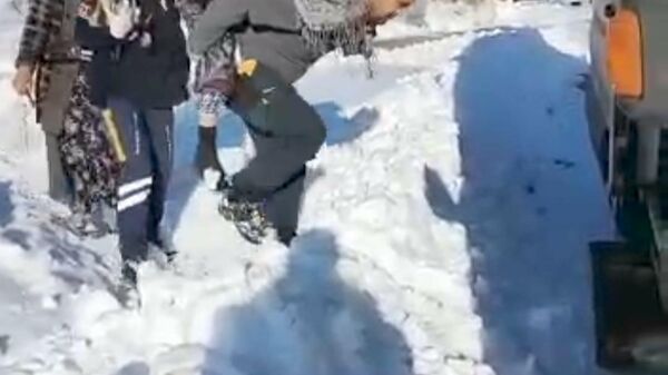 Adıyaman'ın Gölbaşı ilçesinde kar nedeniyle ilerleyemeyen ambulansa hastayı sağlık görevlisi sırtında taşıyarak ulaştırdı. - Sputnik Türkiye
