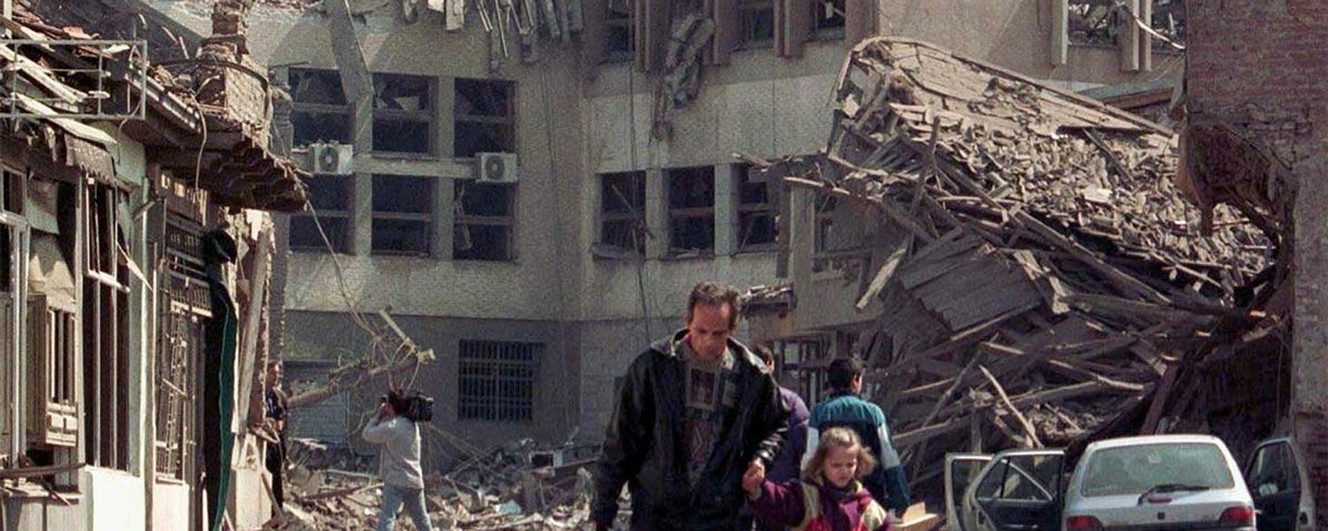 NATO hava saldırılarının Kosova'nın başkenti Priştine'nin merkezini vurmasının ardından bir adam kızını yıkılan binalardan uzaklaştırıyor. - Sputnik Türkiye, 1920, 24.03.2022