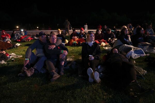 Katılımcılar, uyku tulumları ve battaniyeler içinde, tören alanına kurulan dev ekrandan Çanakkale Savaşları&#x27;na ilişkin belgesel, film, röportaj ve bazı kentlerdeki Anzak Günü törenlerini izleyerek &#x27;Şafak Ayini&#x27;nin başlamasını bekledi. - Sputnik Türkiye