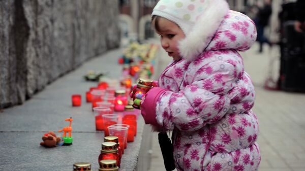 Donbasslı küçük bir kız çocuğu, öldürülen çocuklar anısına mum yakıyor - Sputnik Türkiye