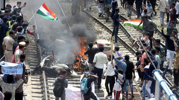 Hindistan'ın 1.6 milyon mensubu olan silahlı kuvvetlerine asker alımını değiştiren ‘Agnipath’ (Ateş Yolu) isimli yeni program, ülke çapında şiddetli protestolarla karşılandı. 17 Haziran'da Secunderabad'da protestocular bir tren istasyonundaki araçları ateşe verdi.  - Sputnik Türkiye