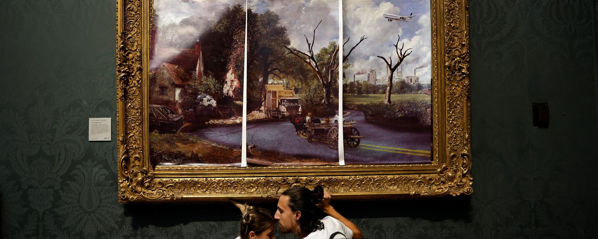 İngiltere’nin başkenti Londra’da bulunan Ulusal Galeri’ye gelen iki iklim aktivisti, ellerini sürdükleri yapıştırıcı ile John Constable’ın 1821 tarihli eseri The Hay Wain’in (Saman Arabası) çerçevesine yapıştırdılar.  - Sputnik Türkiye, 1920, 05.07.2022