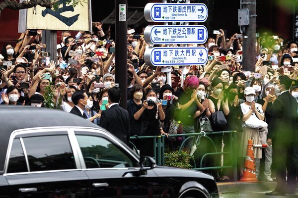 Abe&#x27;yi taşıyan cenaze arabası, öğleden sonra Tokyo&#x27;nun merkezindeki bir tapınaktan ayrılırken, sıkı güvenlik tedbirleri alındı. İnsanlar ellerinde çiçeklerle geçerken alkışladı ve el salladı. - Sputnik Türkiye