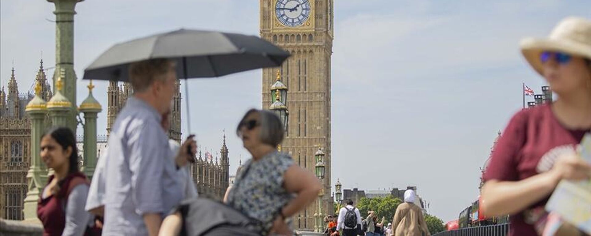 Meteorolojik kayıtların tutulduğundan beri tarihteki en sıcak günlerini Temmuz 2022'de gören İngilizler, Londra'daki Westminster Köprüsü'nde sıcaktan korunarak dolaşırken yüksek enflasyondan nasıl korunacaklarını bilmiyor. - Sputnik Türkiye, 1920, 20.07.2022