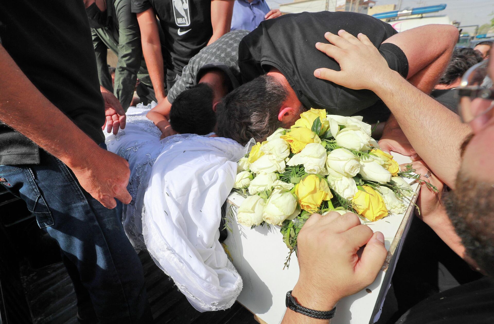 Irak'ta Zaho saldırısının kurbanlarından biri olan ve sadece bir hafta önce evlenmiş bulunan 24 yaşındaki mühendis Abbas Alaa'nın Bağdat'taki cenazesinde yakınları üzüntüyle tabuta sarıldı.  - Sputnik Türkiye, 1920, 22.07.2022