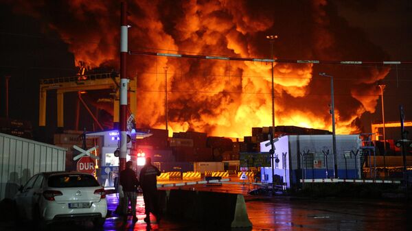 İskenderun Limanı'nda dün depremin ardından devrilen konteynerlerde çıkan yangın sürüyor. - Sputnik Türkiye