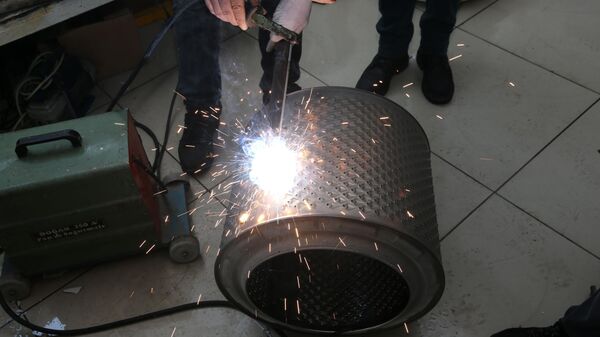 Serviste  teknisyen olarak çalışan Ferhat Hancı, Anadolu Ajansı muhabirine, atıl durumdaki  çamaşır makinesi kazanlarının içinde bulunan çelik tamburlarından soba  yaptıklarını söyledi. - Sputnik Türkiye