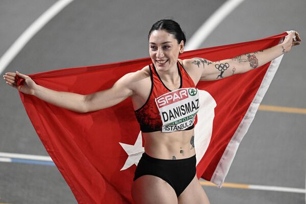 2023 Avrupa Salon Atletizm Şampiyonası'nda kadınlar üç adım atlamada milli sporcu Tuğba Danışmaz, altın madalya elde etti. Milli atlet Tuğba Danışmaz, ilk denemesinde 14,31 metrelik atlayışıyla Türkiye rekoru kırarak Avrupa şampiyonu oldu. - Sputnik Türkiye