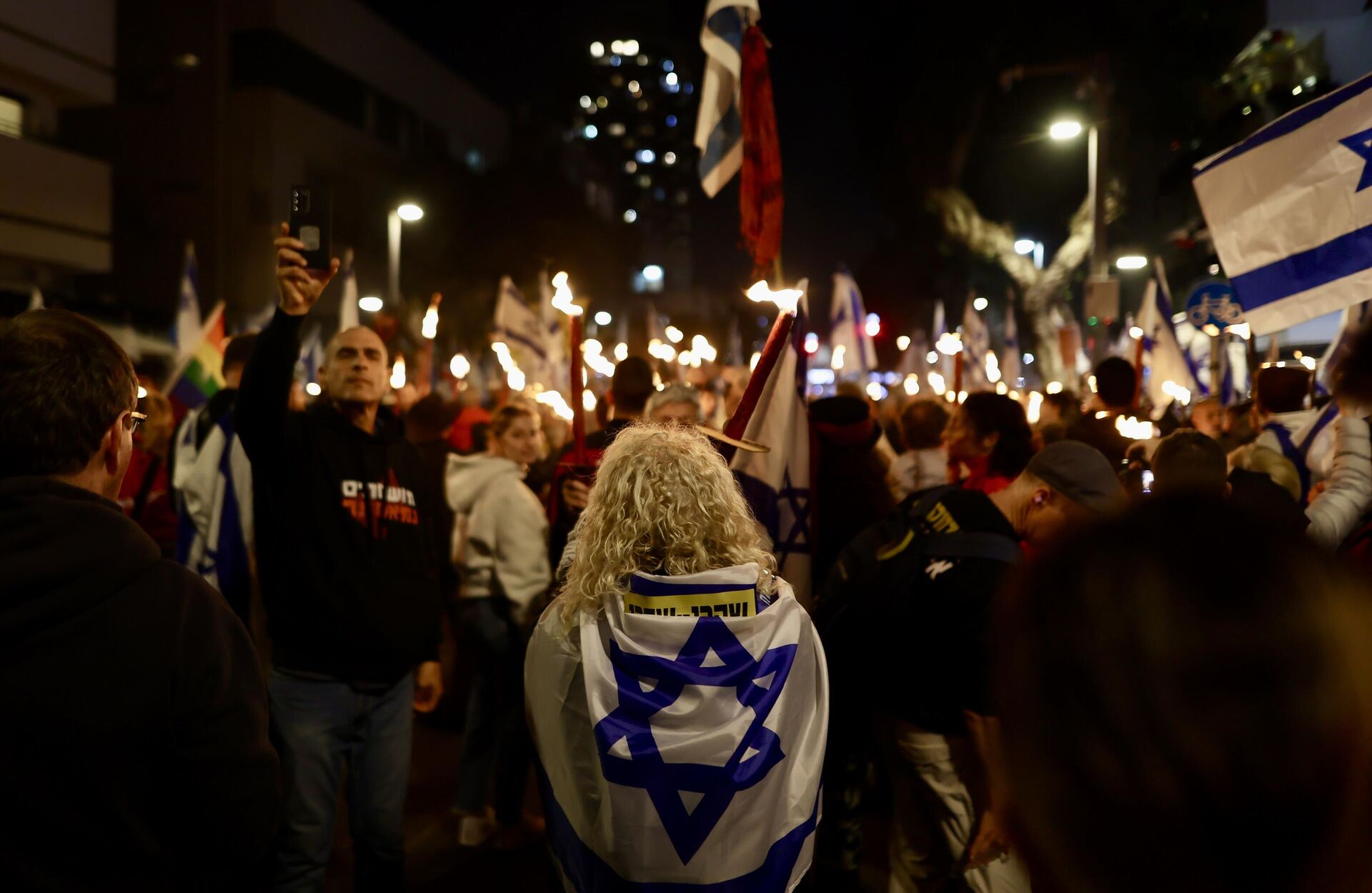 İsrail'de Başbakan Binyamin Netanyahu hükümetinin yargının yetkilerini kısıtlayan yasal düzenlemelerine karşı protestolar sürüyor. Tel Aviv'de toplanan göstericiler, ellerinde İsrail bayrakları taşıyarak meşaleler yaktı.
 - Sputnik Türkiye, 1920, 19.03.2023