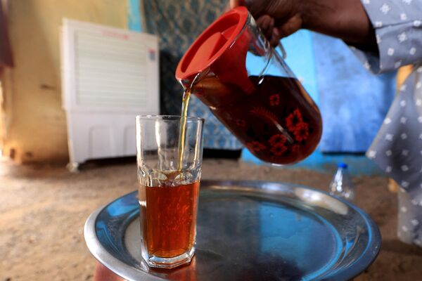 Hartum'da Sudanlı bir kadın, ülkesinin geleneksel Ramazan içeceği Helo Murr'u servis ediyor. Helo Murr, kurutulmuş mısır ve baharatların harmanlanıp suyun içerisinde bekletilmesiyle elde edilen bir çeşit şerbet.  - Sputnik Türkiye