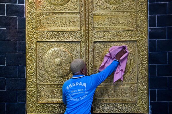 Fotoğrafta, Endonezya'nın Açe şehrinde bir işçi, Beyturrahman Ulu Camii kapısını Ramazan için temizlerken görülüyor. - Sputnik Türkiye