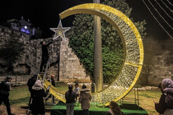 Kudüs'ün Şam Kapısı bölgesinde Ramazan nedeniyle dev bir hilal dekorasyonu yerleştirildi. Filistinliler Ramazan'ı temsil eden hilal ile birlikte fotoğraf çektirdi. - Sputnik Türkiye