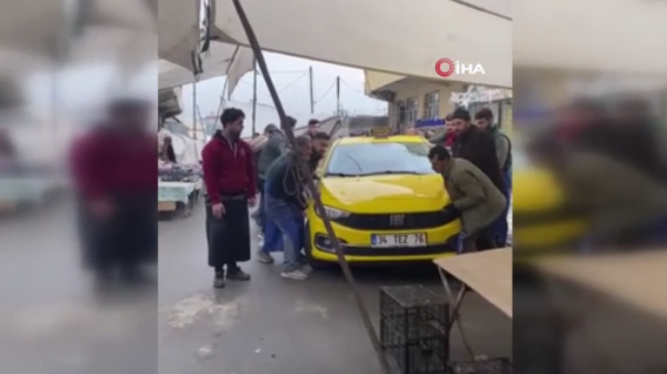 Pazar alanına park edilen taksiyi elleriyle taşıdılar
 - Sputnik Türkiye