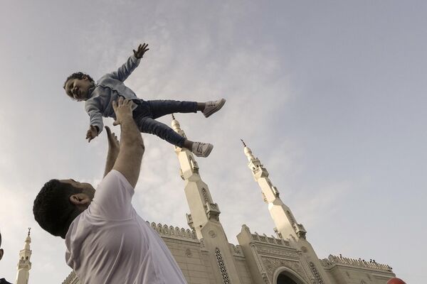 Mısır'ın başkenti Kahire'de babasıyla birlikte bayram namazına giden bir çocuk. - Sputnik Türkiye
