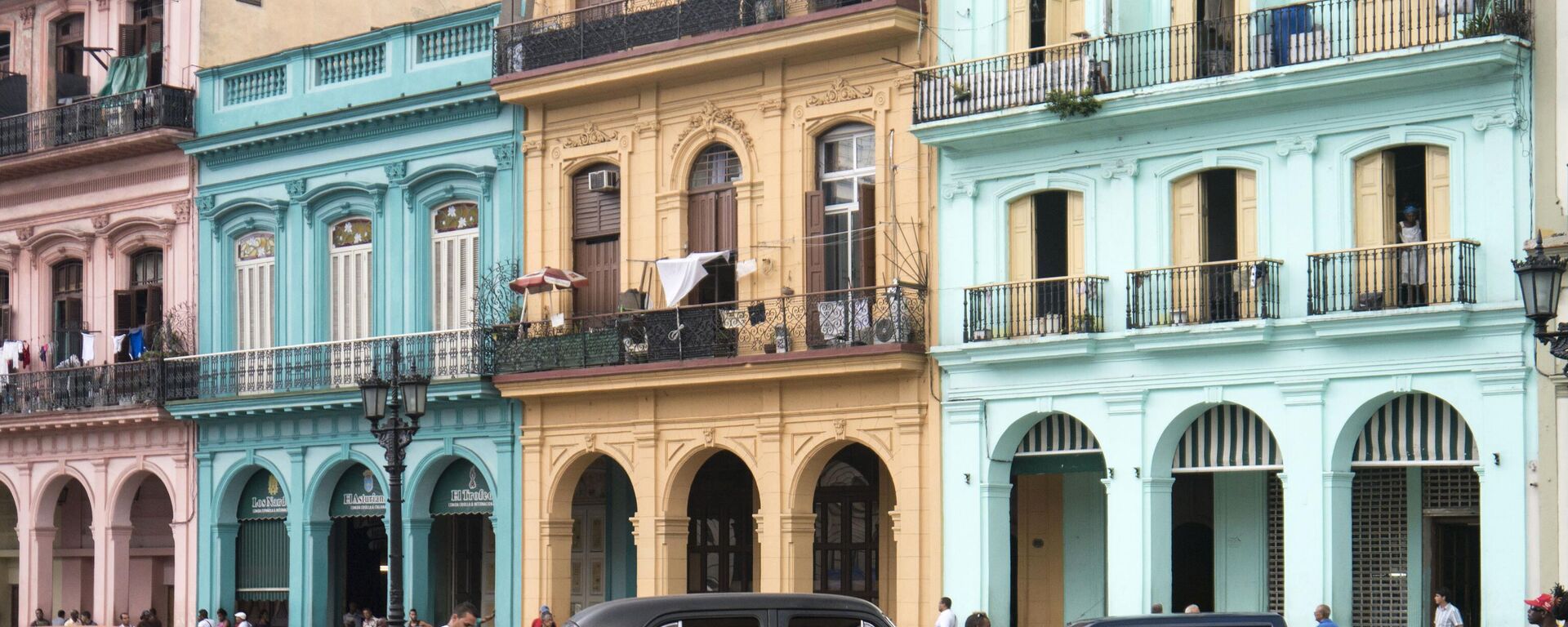 Küba başkenti Havana'nın İspanya sömürgeciliği döneminden kalma yapıları önünde eski arabaları tamir edenler - Sputnik Türkiye, 1920, 21.06.2023