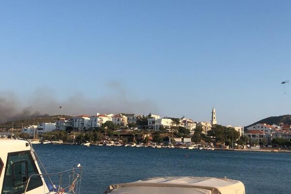 Muğla’nın Datça ilçesinde ormanlık alanda çıkan yangına havadan ve karadan müdahale edilirken, rüzgar ile birlikte şiddetini artıran alevler yerleşim yerlerini tehdit etmeye başladı. - Sputnik Türkiye