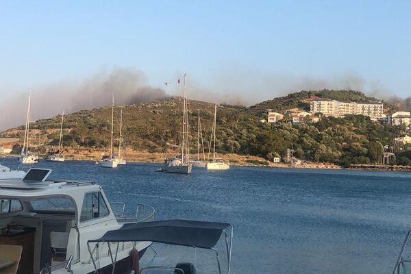 Muğla’nın Datça ilçesinde ormanlık alanda çıkan yangına havadan ve karadan müdahale edilirken, rüzgar ile birlikte şiddetini artıran alevler yerleşim yerlerini tehdit etmeye başladı. - Sputnik Türkiye