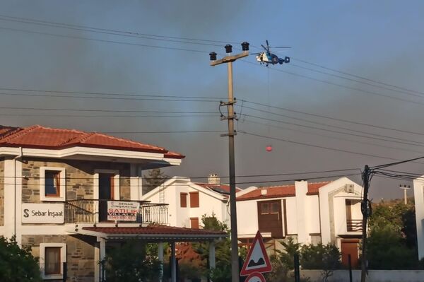 Muğla’nın Datça ilçesinde ormanlık alanda çıkan yangına havadan ve karadan müdahale edilirken, rüzgar ile birlikte şiddetini artıran alevler yerleşim yerlerini tehdit etmeye başladı. - Sputnik Türkiye