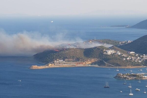 Muğla’nın Datça ilçesinde ormanlık alanda çıkan yangına havadan ve karadan müdahale edilirken, rüzgar ile birlikte şiddetini artıran alevler yerleşim yerlerini tehdit etmeye başladı. - Sputnik Türkiye