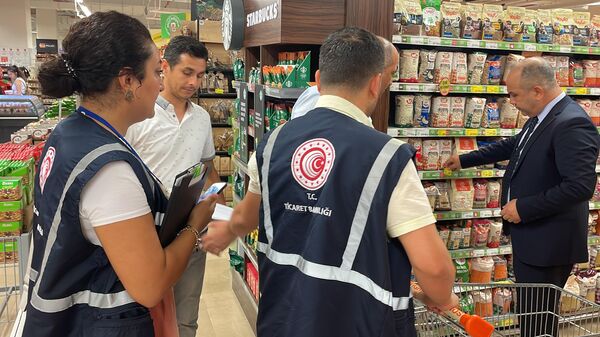 Ticaret Bakanlığı ekipleri, Ankara, İstanbul ve Adana'da marketlerde temel gıda ve ihtiyaç ürünlerine yönelik fahiş fiyat ile etiket denetimi gerçekleştirdi. Adana'da Ticaret İl Müdürü Adnan Ekiz'in de (sağda), katıldığı denetimlerde ekipler 16 firmada 3 bin 6 ürünü reyon ve kasa fiyatları, indirim oranları gibi unsurları gözeterek inceledi.   - Sputnik Türkiye