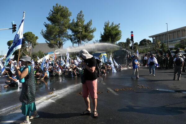 İsrail’de protestolar şiddetleniyor. İsrail Başbakanı Benyamin Netanyahu’nun sunduğu yargı reformu için bugün İsrail Parlamentosu’nda (Knesset) yapılacak oylama öncesi on binlerce İsrailli Tel Aviv ve Kudüs’te protesto gösterileri gerçekleştirirken oylamanın yapılacağı Knesset’te de tepki vardı. - Sputnik Türkiye